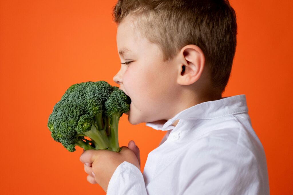 Menino De Camisa Social Branca Segurando Vegetais Verdes